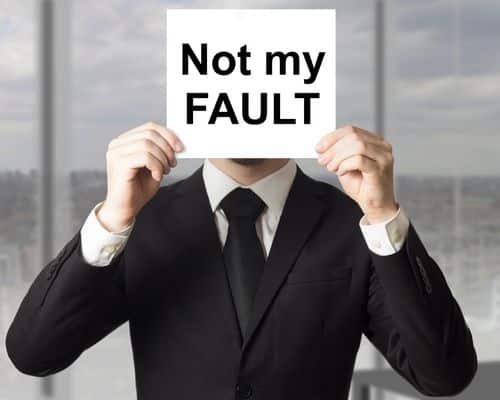 A man in a suit with a sign over his face saying "not my FAULT." This describes his passive aggressive behavior and blameshifting. The name of the article is "Covert Narcissist Checklist: Help to Find the Truth."