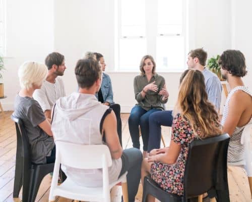 A group of people sitting in folding chairs in a circle, a support group. This photo represents the title of the article, What it Looks Like When God Leads You to Divorce."