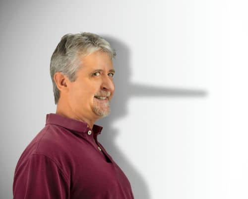 A man standing sideways but looking toward the camera. Behind him is his shadow but with a Pinocchio nose. This picture represents the title of the article, "What Words Does the Bible Use for Narcissists and Narcissism?"